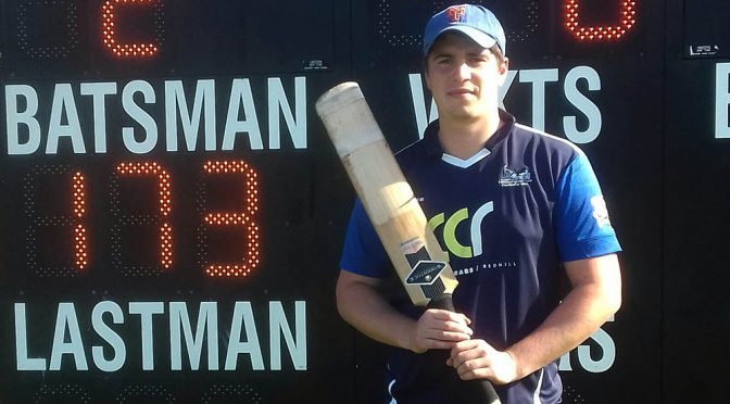 Cricketer Laurie Nicholson next to scoreboard showing his record 173 score.